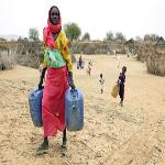 Darfur woman carries water. 